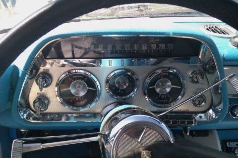 1991 Ford LTD Crown Victoria - The dashboard features a speedometer, fuel gauge, and ammeter, with chrome accents and blue upholstery.