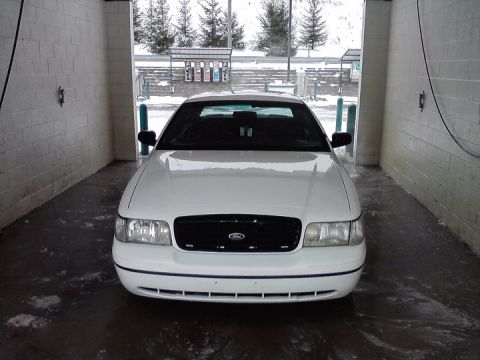 1999 Ford Crown Victoria - A white 1999 Ford Crown Victoria is seen from the front inside a car wash bay.