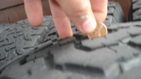1988 Ford Bronco - Penny inserted into tire tread to check depth. The tread appears to be above Lincoln's head.