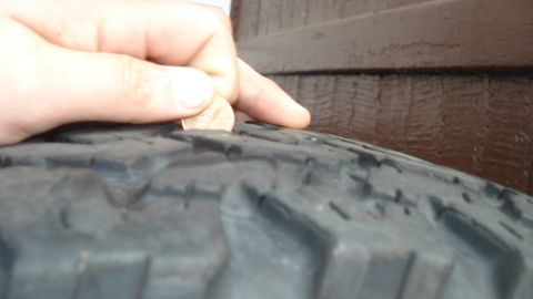 1988 Ford Bronco - Checking tire tread depth with a coin.
