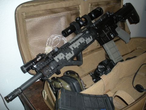 1996 Ford Bronco - Tactical rifle with scope, flashlight, and digital camouflage wrap, stored in a tan tactical bag with headphones and extra magazines.
