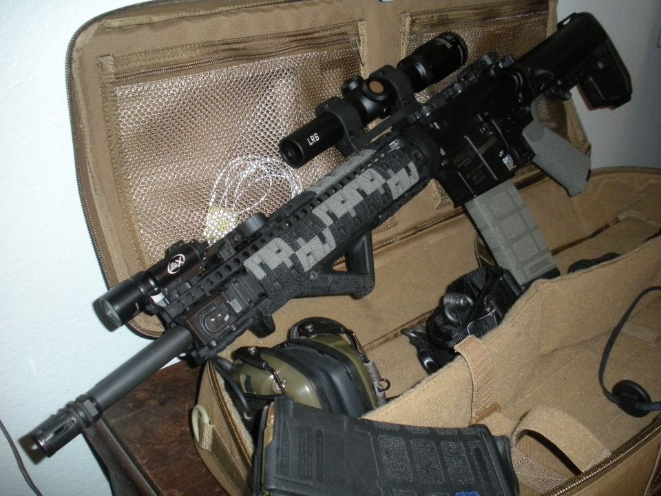 Assault rifle with scope and digital camouflage wrap in a tactical bag