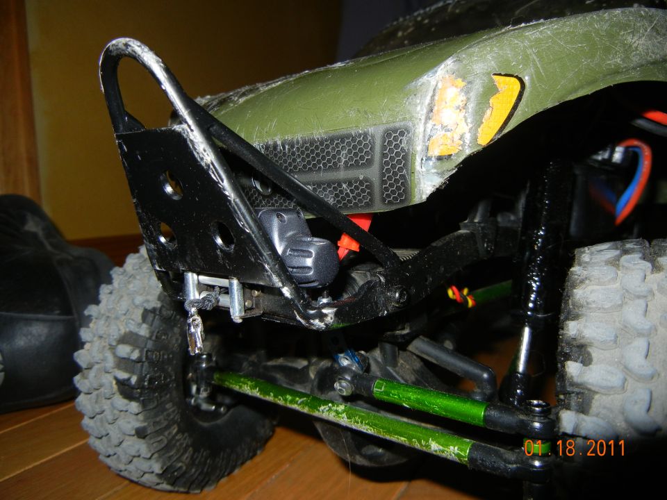 RC car front bumper and green suspension components, close-up
