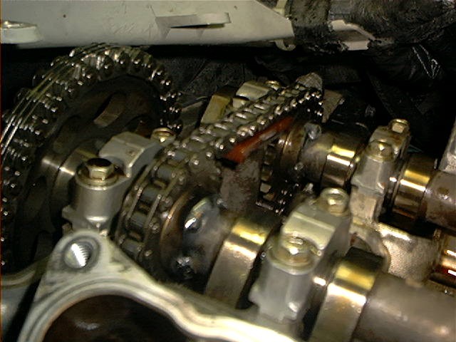 Close-up of timing chain, cam sprocket, and camshafts on an engine with valve cover removed