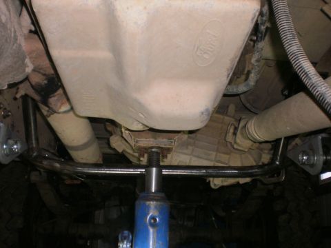 1995 Ford Bronco - Underbody view of a 1995 Ford Bronco, highlighting the transmission crossmember and the Ford logo on the transmission housing.