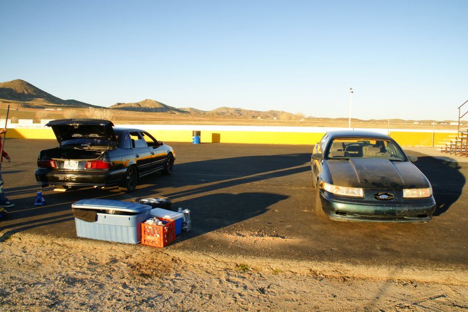 Dark green 1995 Ford Taurus front view, hood is dusty, headlights are clear