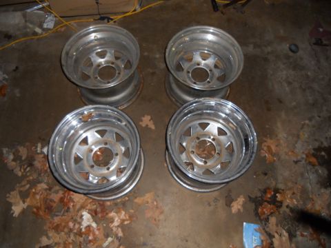 1992 Jeep Cherokee - Four aluminum alloy wheels are shown on a concrete floor with scattered leaves.