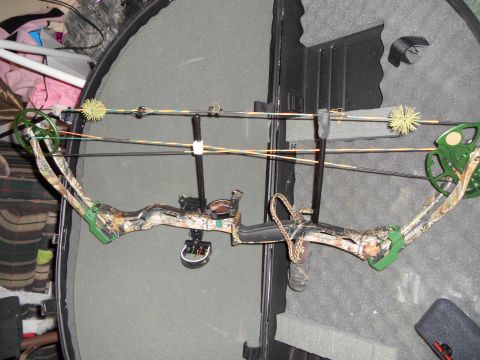 1992 Jeep Cherokee - Compound bow with camouflage limbs and green accents is stored in a protective case.
