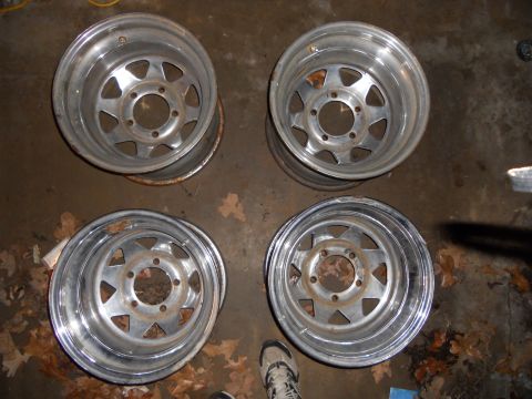 1992 Jeep Cherokee - A set of four chrome wheels, each a five-spoke design, are displayed on a concrete floor.