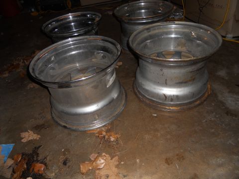 1992 Jeep Cherokee - Set of four aluminum alloy wheels, some showing signs of rust, on a garage floor.