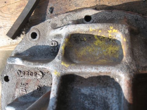 1968 Shelby GT500 - Close-up of a cast iron component showing texture, yellow paint remnants, and stamped markings.