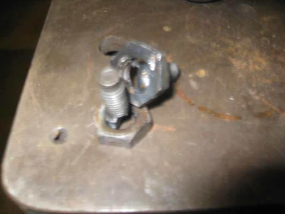 close-up of a metal bracket attached to a bolt with a nut