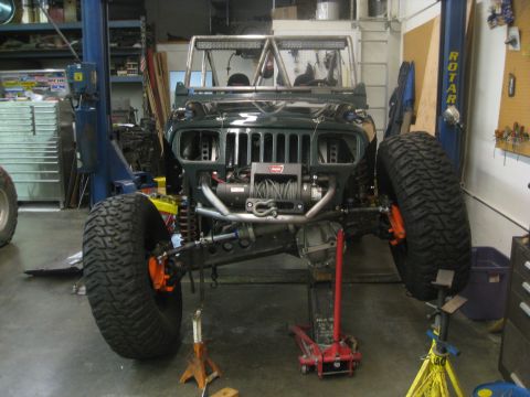 1994 Jeep YJ - This modified Jeep YJ is shown in a garage with its front end elevated for work.