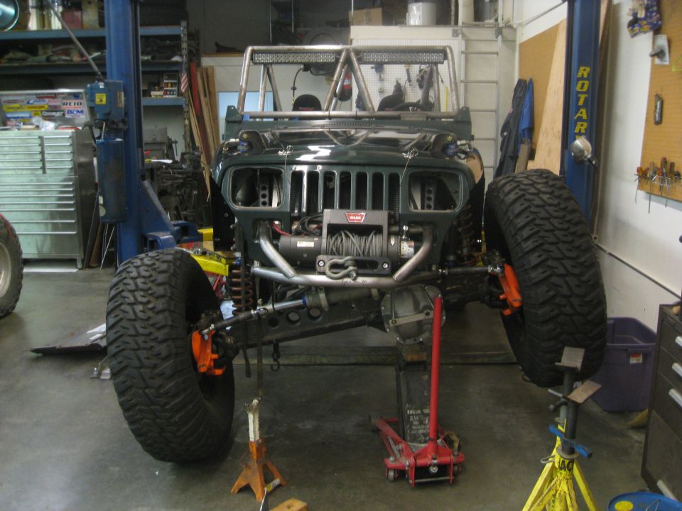Dark green Jeep YJ front view with winch and large tires