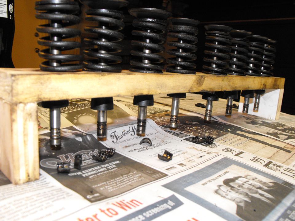 The valves MUST go back into their original guide, when you're lapping. Slip the seal on the valve, underneath, in case you tip the rack over