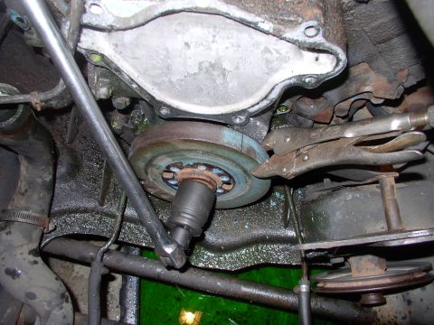 1982 Chrysler New Yorker - Taking the crank bolt out of the balancer with the visegrips holding against the two foot bar.