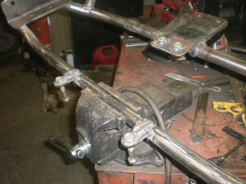1995 Ford Bronco - Metal frame part held in a vise, likely for repair or fabrication work.