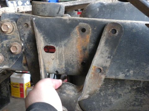 1989 Ford Bronco - A close-up view of a rusty suspension component, likely part of a vehicle's chassis.