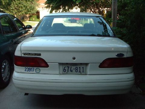 1996 Ford Taurus - 1996 Ford Taurus rear view, parked next to a dark colored vehicle.