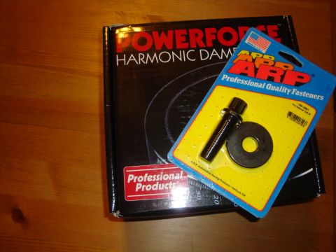 1989 Ford Bronco - ARP fastener kit and Powerforce harmonic damper box shown on a wooden surface.
