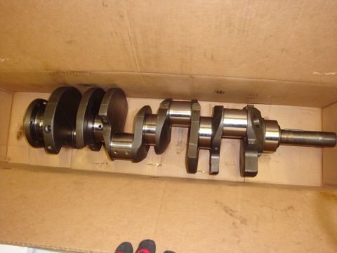 1989 Ford Bronco - A crankshaft lies in a cardboard box, likely for an engine rebuild.
