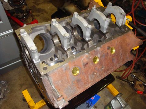 1989 Ford Bronco - Engine block with crankshaft bearings and connecting rods visible, resting on an engine stand.