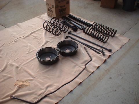 1967 Ford Galaxie - Various car parts are laid out on a tarp on a concrete surface.