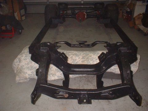 1967 Ford Galaxie - A car frame, likely undergoing restoration, is shown with its rear axle and suspension parts. The image is from SuperMotors.net.