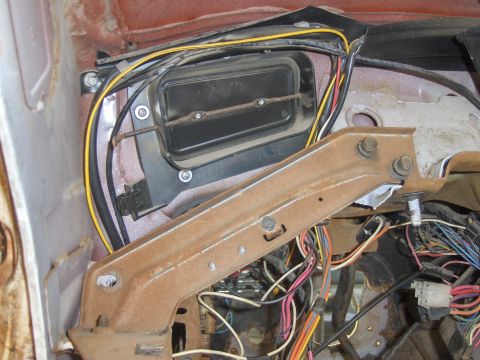 1972 Chevrolet Camaro - Close-up of a car's interior reveals a complex network of wires and an HVAC duct, with visible rust on a metal bracket.