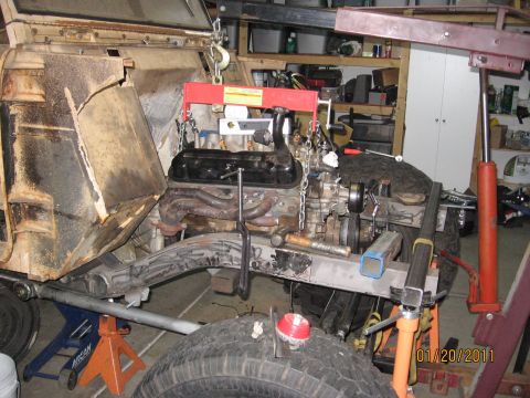 1961 International Scout 800 - Engine installation in progress, supported by an engine hoist and jack stands.