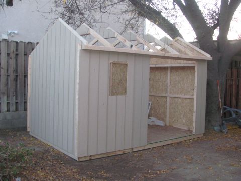 1968 Ford Mustang - A shed is under construction with exposed roof rafters and unfinished interior walls.