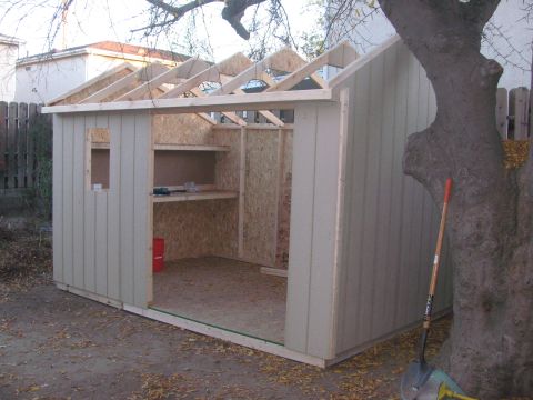1968 Ford Mustang - A shed is being built, showing its framing and exterior siding, with a shovel nearby.