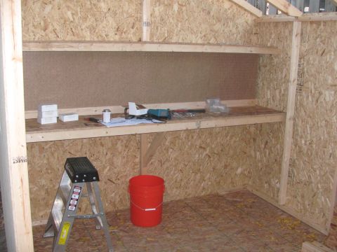 1968 Ford Mustang - The interior of a shed shows unfinished shelving, a ladder, a bucket, and various tools.