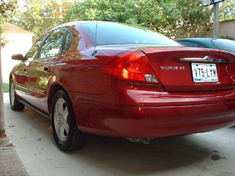 1996 Ford Taurus - Rear view of a red sedan, identified as a Taurus SE, with license plate V75-LYM.