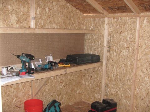 1968 Ford Mustang - The interior of a shed is shown, with tools and storage containers on wooden shelves.