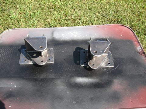 1995 Ford F-150 - Two custom metal brackets are shown on a dark surface, with grass visible in the background.