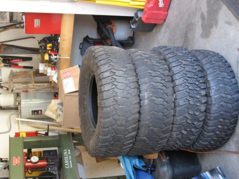 1995 Ford F-150 - A set of four off-road tires are visible in a cluttered garage setting.