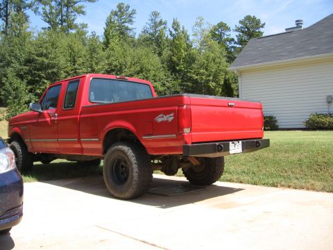 1995 Ford F-150 - Rear view of a red 1995 Ford F-150 pickup truck with a 4x4 decal.