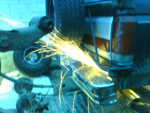 1989 Ford Bronco - Grinding metal sparks fly near a tire and part of a vehicle's rear.
