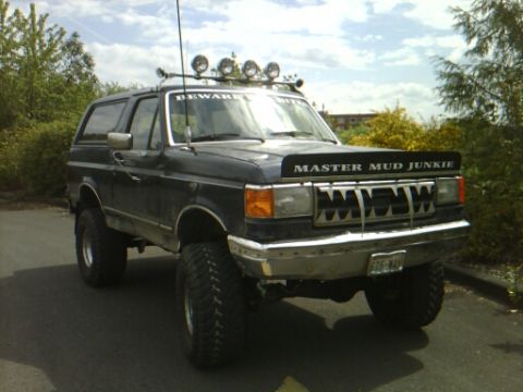 1989 Ford Bronco - This lifted Bronco features a custom grille and extra lights on the roof rack.