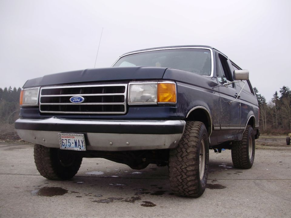 1989 Ford Bronco SUV, dark blue, with aftermarket wheels and tires
