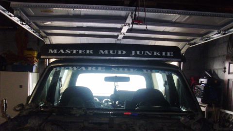 1989 Ford Bronco - The interior of an SUV is visible, with a roof-mounted rack displaying 'MASTER MUD JUNKIE'.