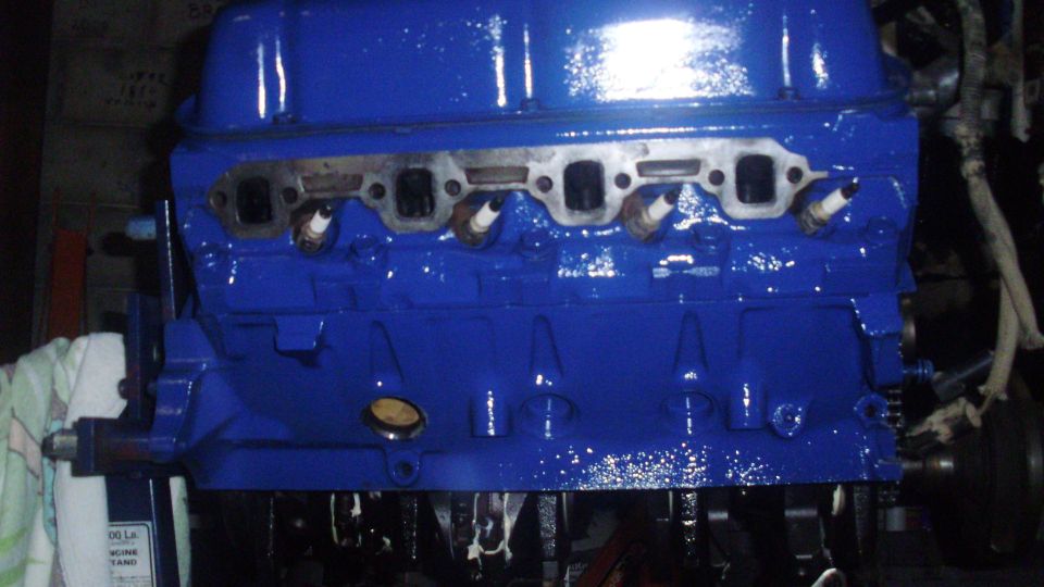 blue painted engine block with spark plugs installed