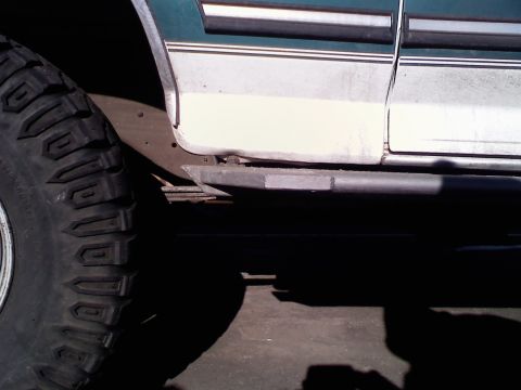 1996 Ford Bronco - Close-up side view of a 1996 Ford Bronco, highlighting its off-road tire and slider bar.