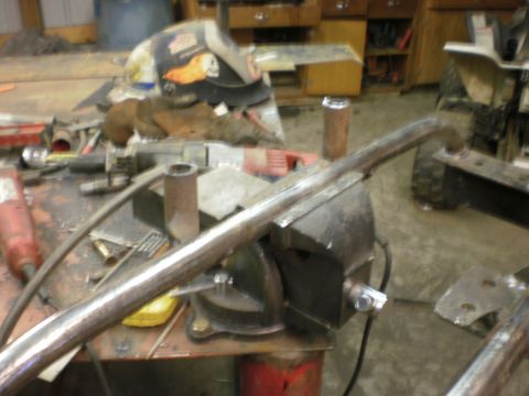 1995 Ford Bronco - A metal pipe is secured in a vise, surrounded by tools and workshop equipment.