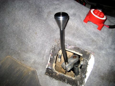 1996 Ford Bronco - The interior of a vehicle shows a close-up of the transfer case shifter mechanism and a red battery disconnect switch.
