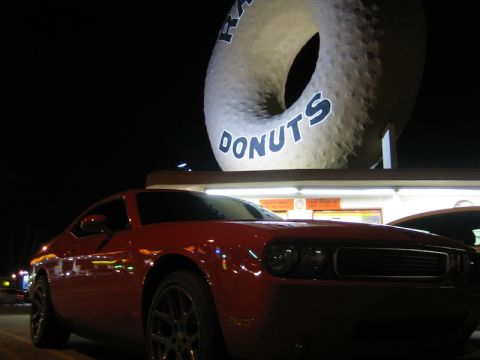 2010 Dodge Challenger - A red Dodge Challenger is parked in front of a large donut sign at night.