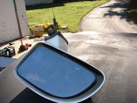 1973 Ford Ranchero - A detached side mirror sits on a surface, reflecting the sky and clouds.