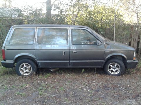 1989 Dodge Caravan - Side view of a gray 1989 Dodge Caravan with "INTERCOOLED TURBO" text on the door.