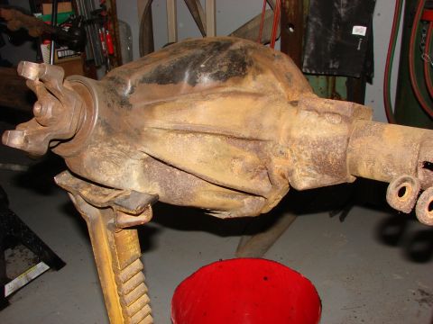 1971 International School Bus - Differential housing sits on a jack stand, showing signs of rust and wear.